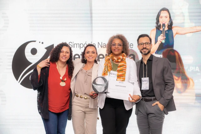 Palestrantes posando para foto no palco