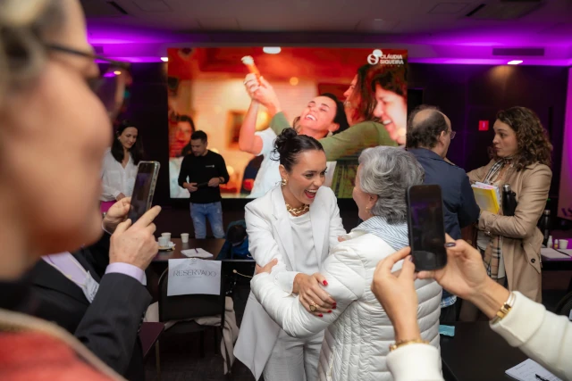 Cláudia cumprimentando os participantes