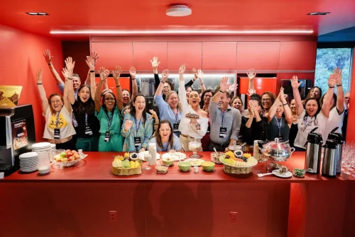 Participantes do simpósio levantando as mãos na cozinha