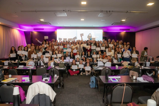 Participantes do simpósio segurando certificado no palco