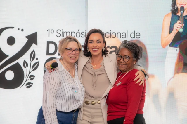 Cláudia abraçando os participantes do Simpósio